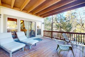 a porch with white chairs and a wooden deck at Arrowhead Haven in Lake Arrowhead