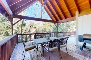 a patio with a table and chairs on a deck at Arrowhead Haven in Lake Arrowhead