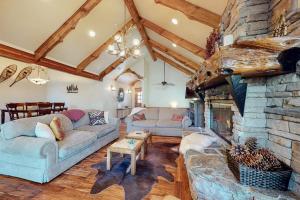 a living room with a large stone fireplace at Arrowhead Haven in Lake Arrowhead