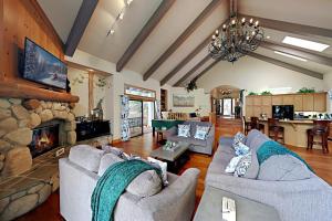 a living room with couches and a stone fireplace at Emerald Oasis in Lake Arrowhead