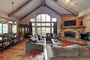 a living room with couches and a stone fireplace at Emerald Oasis in Lake Arrowhead +38 photos
