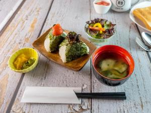 a table with a plate of food and a bowl of soup at HOTEL R9 SanoFujioka in Sano +16 photos