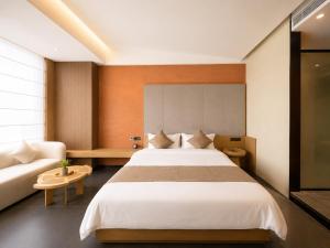a bedroom with a large bed and a couch at Clover Hotel & Spa in Phnom Penh