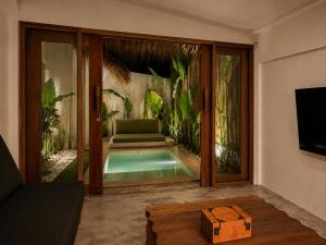 a living room with a swimming pool and a tv at Villa Xana - Private pool - SOFT OPENING in General Luna