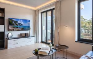 a living room with large windows and a tv at Princess in Binz