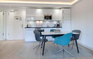 a kitchen with white cabinets and a table and chairs at Princess in Binz