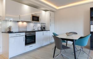 a kitchen with white cabinets and a table and chairs at Princess in Binz +33 photos