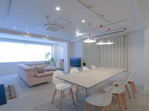 a living room with a table and chairs and a couch at INOVE VILLA OSAKA -120m2 , 7 Double Beds , 2 BR , 2 Bath , Easy Access to Umeda , Kyoto ーPerfect for Families & Groupsー in Osaka