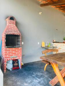 a brick oven in a room with a table at Chalé Brisa da Lagoa in Icaraí