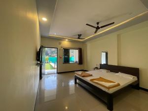 a bedroom with a bed and a ceiling at Shree Krishna Sudha Resort in Alibaug +14 photos