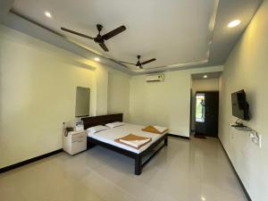 a bedroom with a bed and a tv in it at Shree Krishna Sudha Resort in Alibaug