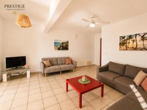 a living room with two couches and a table at Petit Havre de Paix BIS - Piscine et plage à pied in Le Gosier