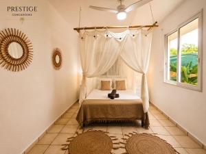 a bedroom with a bed and a window at Petit Havre de Paix BIS - Piscine et plage à pied in Le Gosier +9 photos