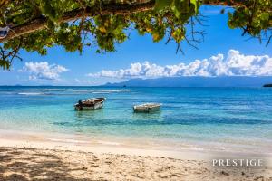 two boats sitting in the water on a beach at Petit Havre de Paix BIS - Piscine et plage à pied in Le Gosier