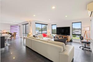 a living room with a white couch and a television at Marlin Vista - Pet Friendly in Eden