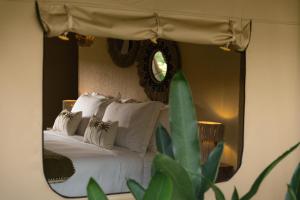 a bedroom with a bed with a mirror at Vela Tianyar Boutique Resort - Oceanfront in Tianyar