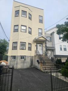 a tall building with a white door and stairs at Hillside Appartment #2 in Newark