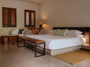 ein Schlafzimmer mit einem Bett, einem Tisch und Stühlen in der Unterkunft Lo Sereno Casa de Playa in Troncones