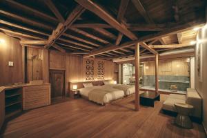 a bedroom with a bed in a room with wooden walls at KAZENO Kurayoshi in Kurayoshi