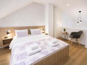 a bedroom with a large bed with two towels on it at Villa Diamond in Mostar +25 photos