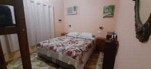 a bedroom with a bed with a red and white blanket at Casa con piscina en Gobernador Roca in Gobernador Roca +6 photos