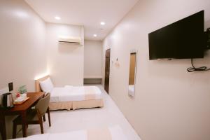 a hotel room with a bed and a desk and a television at Rovers Hotel Kubang Kerian in Kota Bharu