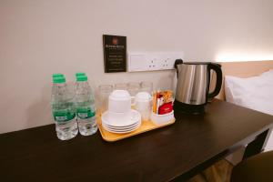 a table with two bottles of water and plates at Rovers Hotel Kubang Kerian in Kota Bharu