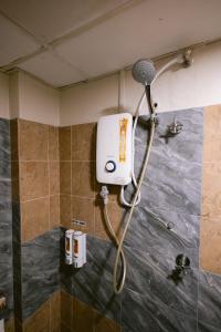 a shower in a bathroom with a shower head at Rovers Hotel Kubang Kerian in Kota Bharu +51 photos