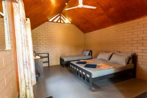 a room with a bed and a bench in it at Cinnamon Village Sinharaja in Deniyaya +88 photos