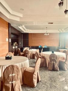 a dining room with tables and chairs and tablesearcher at Jati Hotel in Ternate