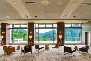 a lobby with chairs and windows with a view at TAOYA Gero in Gero