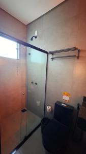 a bathroom with a glass shower and a toilet at Pousada Veredas da Canastra in Delfinópolis