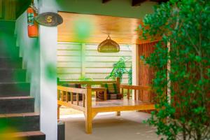 a porch with a wooden bench and a table at Garden Chalets Koh Lanta in Ko Lanta