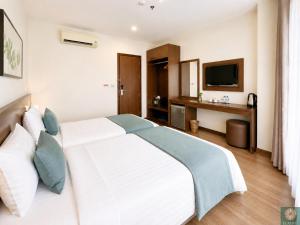 a bedroom with a white bed and a television at Corner Central Danang City Hotel in Danang +9 photos