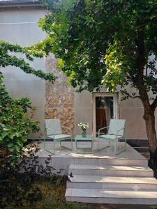two chairs and a table in front of a building at Баракат in Chon-Sary-Oy
