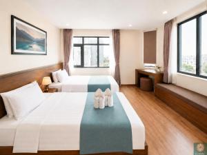 two beds in a hotel room with shoes on the bed at Corner Central Danang City Hotel in Danang