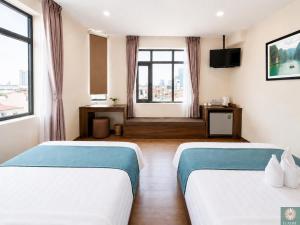 a hotel room with two beds and a television at Corner Central Danang City Hotel in Danang