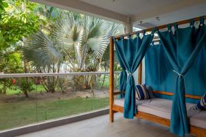 a bedroom with a bed and a large window at Blue Mango Beach Hotel in Guachaca