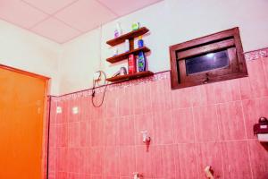a bathroom with a shower with a tv on the wall at Claasz Prime Lagoon in Katunayaka
