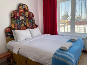 a bedroom with a large bed and a window at Duet hostel in Karakol