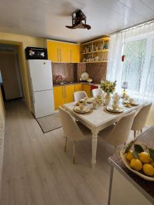 a kitchen with a table with chairs and yellow cabinets at Баракат in Chon-Sary-Oy