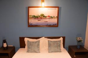 a bedroom with a bed with a picture on the wall at Claasz Prime Lagoon in Katunayaka