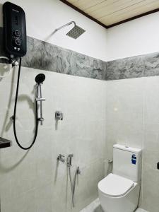a bathroom with a shower and a toilet in it at Luna Mara in Arugam Bay