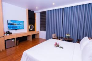a hotel room with a bed and a television at CELINA HOTEL Ninh Bình in Ninh Binh