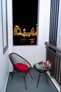 a balcony with two chairs and a table with a red pillow at CELINA HOTEL Ninh Bình in Ninh Binh