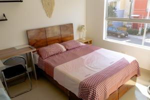 a bedroom with a bed with a desk and a window at Don Checho's House in Ica +23 photos