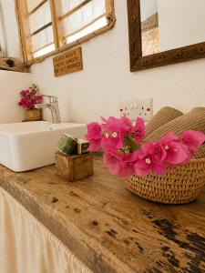 a bathroom with a sink and flowers on a counter at Kita Ocean House in Kiwengwa