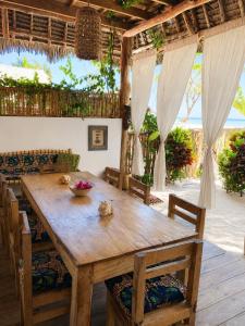 a dining room with a wooden table and chairs at Kita Ocean House in Kiwengwa