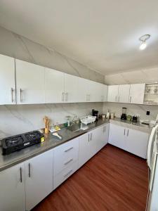 a kitchen with white cabinets and stainless steel appliances at Hostal Beko in Cali