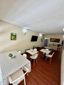 a room with tables and chairs and a flat screen tv at Hostal Beko in Cali